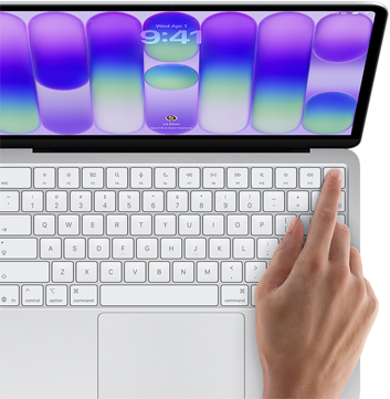 MacBook Neo, Farbe Silber, Anmeldebildschirm, ein Finger berührt den Touch ID Sensor oben rechts auf der Tastatur