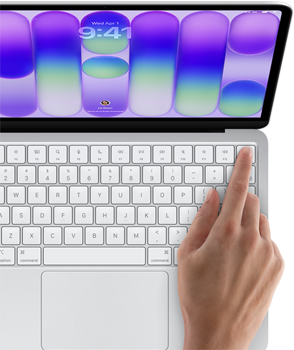 MacBook Neo, Farbe Silber, Anmeldebildschirm, ein Finger berührt den Touch ID Sensor oben rechts auf der Tastatur